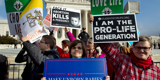 FILE - In this Friday, Jan. 18, 2019 file photo, anti-abortion activists protest outside of the U.S. Supreme Court, during the March for Life in Washington. (AP Photo/Jose Luis Magana)