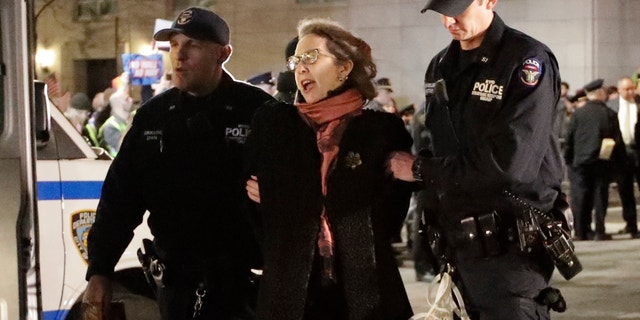 A protester is taken into custody outside Trump International Hotel & Tower on Friday, Feb. 15, 2019, in New York. Some people have been arrested while protesting President Donald Trump's national emergency declaration. The NYPD wasn't immediately able to say how many people were taken into custody outside the hotel. (AP Photo/Frank Franklin II)