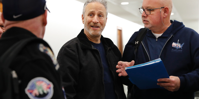 Entertainer and activist Jon Stewart, center, speaks with members of the FealGood Foundation as they arrive on Capitol Hill to speak with lawmakers about the compensation fund for victims of 9/11, Monday, Feb. 25, 2019, on Capitol Hill in Washington. Stewart has been involved in urging support for the first responders, volunteers, and survivors of the September 11 attacks. (AP Photo/Jacquelyn Martin)
