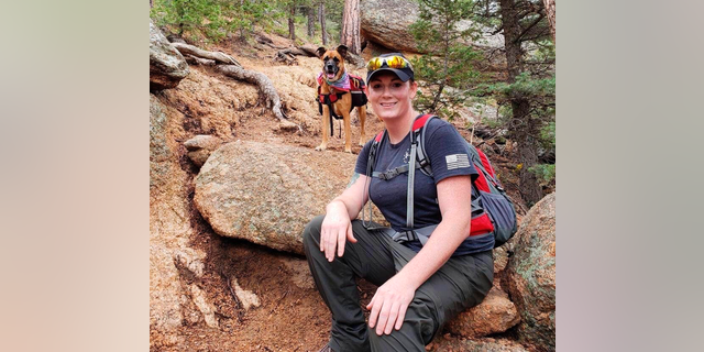 This undated photo provided by her wife Jessica Kibodeaux shows Lindsey Muller and her dog Emma hiking in the Cheyenne Mountains west of Fort Carson, Colo. Muller, a 19-year combat veteran who served multiple tours in Iraq, diligently followed the Pentagon guidelines to transition. In the nearly three years since the U.S. military welcomed transgender people into the armed forces in 2016, they have served without incident. Some, like Muller, have earned prestigious medals or received other forms of recognition. (Jessica Kibodeaux via AP)