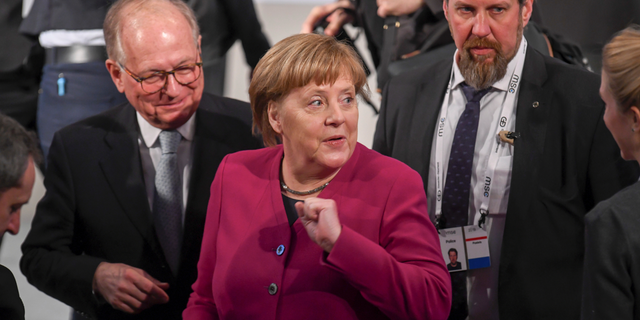 German Chancellor Angele Merkel, center, arrives for a meeting during the Munich Security Conference in Munich, Germany, Saturday, Feb. 16, 2019. (Tobias Hase/dpa via AP)