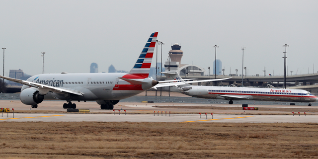 Jets line up on the tarmac at Dallas/Fort Worth International Airport in Grapevine, Dallas, Wednesday, Feb. 13, 2019. Flights at Dallas' two major airports were temporarily halted after air traffic controllers were forced to evacuate a building because of smoke, and the resulting flight delays are expected to continue for hours. (AP Photo/LM Otero)