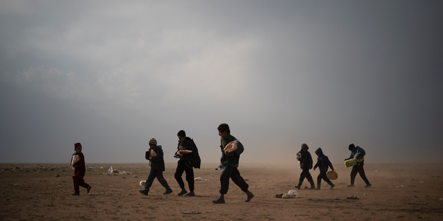 Children evacuated out of the last territory held by Islamic State militants walk at a screening center after collecting food, outside Baghouz, Syria, Tuesday, Feb. 26, 2019. Evacuations have continued amid a standoff between the militants and the U.S.-backed Syrian Democratic Forces (SDF). (AP Photo/Felipe Dana)