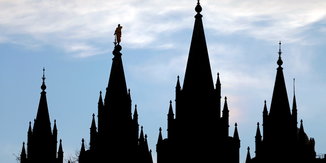 FILE- In this Jan. 3, 2018, file photo, the angel Moroni statue, silhouetted against the sky, sits atop the Salt Lake Temple at Temple Square in Salt Lake City. The Mormon church won't stand in the way of a proposal to ban gay conversion therapy for minors in its home base of Utah, a position that advocates heralded as a milestone in the conservative state. (AP Photo/Rick Bowmer, File)
