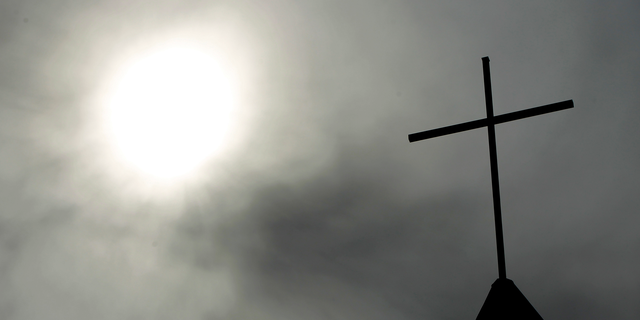 A cross sits on top of a church in Berlin, Germany. Pope Francis' high-stakes sex abuse prevention summit is meant to call attention to the crisis as a global problem that requires a global response. (AP Photo/Markus Schreiber, File)