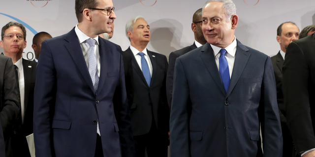 File -- In this Thursday, Feb. 14, 2019 photo Poland's Prime Minister Mateusz Morawiecki, left, and Israeli Prime Minister Benjamin Netanyahu, right, attend a group photo during a meeting in Warsaw, Poland. Poland's prime minister canceled plans for his country to send a delegation to meeting in Jerusalem on Monday after the acting Israeli foreign minister Israel Katz said that Poles "collaborated with the Nazis" and "sucked anti-Semitism from their mothers' milk". (AP Photo/Michael Sohn)