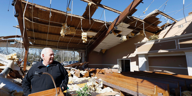 Pastor Steve Blaylock looks over the broken lumber, loose paneling, insulation, and destroyed pews in the First Pentecostal Church in Columbus, Miss., Sunday morning, Feb. 24, 2019 after a Saturday tornado. While no-one was injured during the storm, at least one person was killed in town among the shattered businesses and wrecked homes. (AP Photo/Rogelio V. Solis)