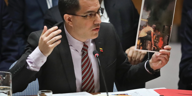 Venezuela Foreign Affairs Minister Jorge Arreaza shows picture he said represent opposition members initiating violence, during a meeting on Venezuela in the U.N. Security Council at U.N. headquarters, Tuesday Feb. 26, 2019. (AP Photo/Bebeto Matthews)
