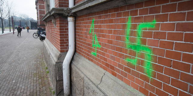 A Swastika, painted on the wall of the Stedelijk Museum overnight, is seen in Amsterdam, Netherlands, Friday, Feb. 22, 2019. Vandals suspected of being football hooligans from The Hague have daubed graffiti including swastikas and anti-Semitic texts on buildings in Amsterdam. The graffiti were discovered Friday, ahead of a match Sunday between ADO and Amsterdam powerhouse Ajax. Ajax fans are banned from attending the match following previous clashes between fans of the two clubs. (AP Photo/Peter Dejong)