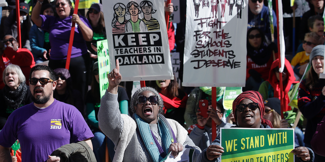 FILE - In this Thursday, Feb. 21, 2019 file photo, teachers, students and supporters rally at Frank Ogawa Plaza in front of City Hall in Oakland, Calif. Teachers in Oakland are preparing to strike for a third day after negotiations with the school district broke down over the weekend. (AP Photo/Jeff Chiu, File)
