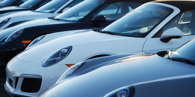 In this Sunday, Feb. 3, 2019, photograph, a long row of unsold 2019 911 Carrera GTS cabriolets sits at a Porsche dealership in Littleton, Colo. Borrowers are behind in their auto loan payments in numbers not seen since delinquencies peaked at the end of 2010, according to the Federal Reserve Bank of New York. (AP Photo/David Zalubowski)
