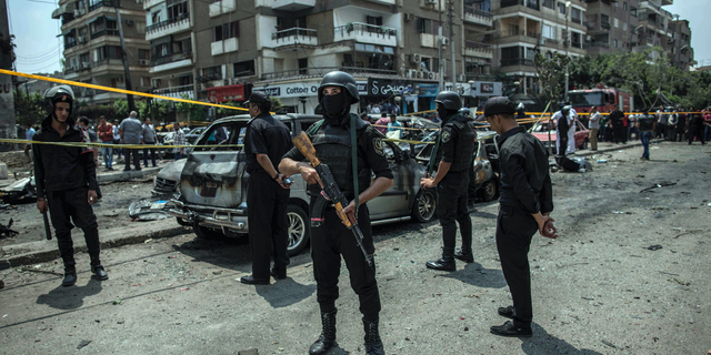 FILE -- In this June 29, 2015 file photo, Egyptian policemen stand guard at the site of a bombing that killed Egypt's top prosecutor, Hisham Barakat, who oversaw cases against thousands of Islamists, in Cairo. On Wednesday, Feb. 20, 2019 Egypt executed nine suspected Muslim Brotherhood members convicted of involvement in the 2015 assassination of Barakat, security officials said. The nine were found guilty of taking part in the bombing that killed Barakat, the first assassination of a senior official in Egypt in a quarter century. (AP Photo/Eman Helal, File)