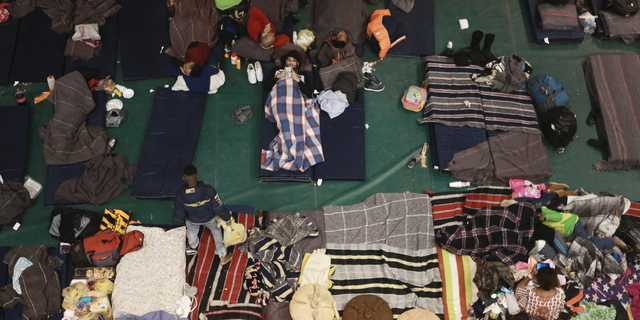 In this Tuesday, Feb. 19, 2019 photo, migrants from Central America, Africa and the Caribbean, who are awaiting their turns to request asylum in the U.S., pass the time inside a shelter in Bachilleres gymnasium in Ciudad Juarez, Mexico. Hundreds of migrants, some of whom arrived from the recently closed shelter in Piedras Negras on the Mexico-U.S. border, are camped out in the gym waiting their chance to submit their asylum request at the El Paso port of entry. (AP Photo/Christian Torres)