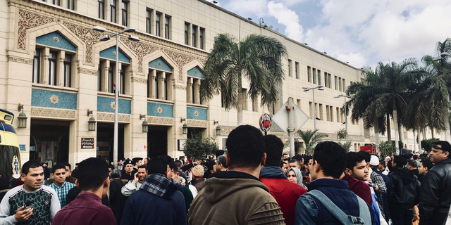 People gather outside Ramsis train station in Cairo, Egypt, Wednesday, Feb. 27, 2019. An Egyptian medical official says 20 people have been killed and dozens injured when a major fire erupted at the main train station in Cairo. Mohammed Said, the head of the Cairo Railroad hospital, says the death toll is expected to rise further following the blaze on Wednesday. (AP Photo/Nariman El-Mofty)