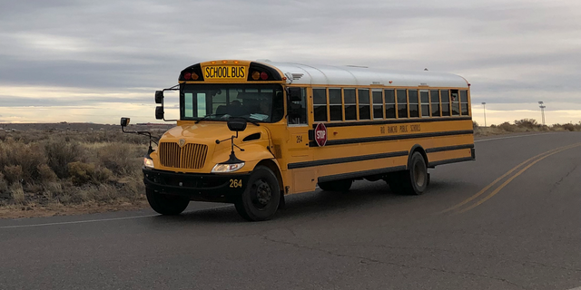 A school bus evacuates students from Sue V. Cleveland High School in Rio Rancho, New Mexico, on Thursday, Feb. 14, 2019, after a shot was fired on the campus. Police and school officials said no one was injured and a suspect was taken into custody. (AP/Russell Contreras)