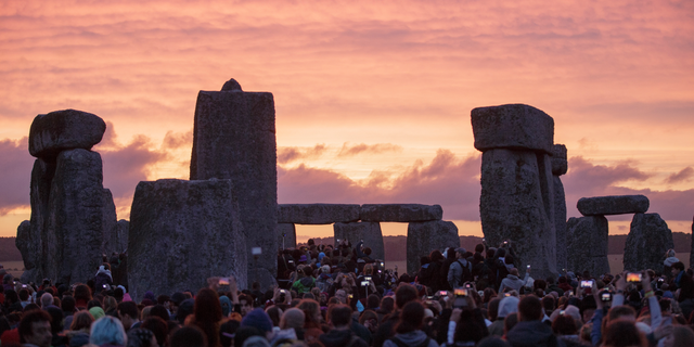 FILE - In this Sunday, June 21, 2015 file photo, the sun rises as thousands of revellers gather at the ancient stone circle Stonehenge to celebrate the Summer Solstice, near Salisbury, England. A new study suggests the practice of building huge stone monuments was spread throughout ancient Europe from northwestern France. In an email Tuesday, Feb. 12 2019 Bettina Schulz Paulsson of the University of Gothenburg said the findings challenge previous theories that claimed megaliths originated in the Middle East or independently in different parts of Europe.(AP Photo/Tim Ireland, file)