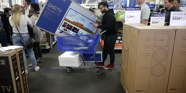 FILE- In this Nov. 22, 2018, file photo people wait in line to buy televisions as they shop during an early Black Friday sale at a Best Buy store on Thanksgiving Day in Overland Park, Kan. Best Buy Co., Inc. reports financial results Wednesday, Feb. 27, 2019. (AP Photo/Charlie Riedel, FIle)