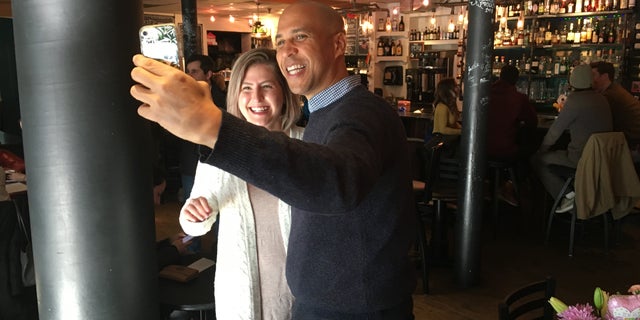 Sen. Cory Booker taking a photo with a voter in Nashua, N.H., in December 2018.
