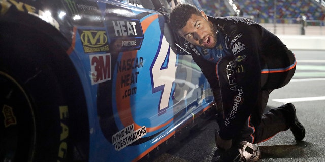 Darrell Wallace Jr. adjusts his driving shoes before getting into his car before the first of two qualifying auto races for the NASCAR Daytona 500 at Daytona International Speedway, Thursday, in Daytona Beach, Fla. (AP Photo/John Raoux)