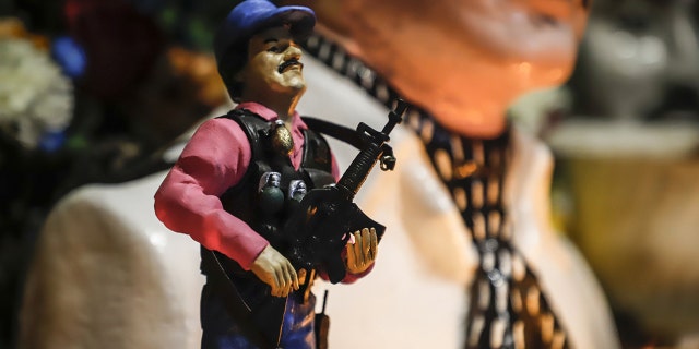 A statue of Mexican drug lord Joaquin "El Chapo" Guzman, is displayed for sale near a bust of narco-saint Jesus Malverde, at his chapel in Culiacan, Sinaloa state in northwest Mexico on Feb. 19. (Photo by RASHIDE FRIAS / AFP) (Photo credit should read RASHIDE FRIAS/AFP/Getty Images)