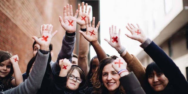 People put a red X on their hand to raise awareness for the "End It Movement," in an effort to end modern-day slavery.