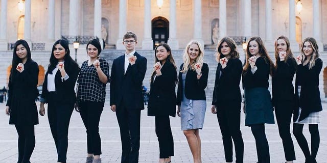 People participate in "Shine a Light on Slavery Day" by marking a red X on their hand.