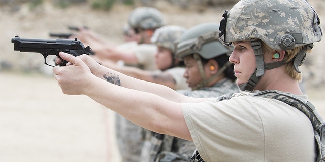 Senior Airman Clare Slater aiming M9 gun, in line with her colleagues, Gowen Field, Boise, Idaho. (Photo by Smith Collection/Gado/Getty Images)