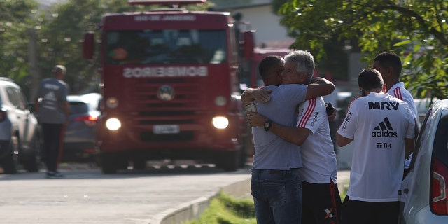 People wait for information in front of the training center of Rio's soccer club Flamengo, after a deadly fire