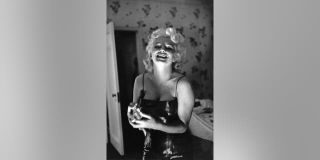 NEW YORK - MARCH 24: Actress Marilyn Monroe gets ready to go see the play "Cat On A Hot Tin Roof" playfully applying her makeup and Chanel No. 5 Perfume on March 24, 1955 at the Ambassador Hotel in New York City, New York.