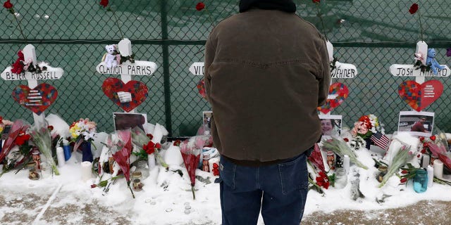 A man prays at a makeshift memorial Sunday, Feb. 17, 2019, in Aurora, Ill., near Henry Pratt Co. manufacturing company where several were killed on Friday. (AP Photo/Nam Y. Huh)