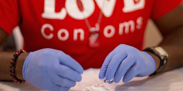 FILE - In this June 27, 2013 file photo, Reggie Batiste, program manager with AIDS Healthcare Foundation, administers a free HIV test as part of National HIV Testing Day in Atlanta. Just three weeks after President Donald Trump launched a campaign to end the U.S. HIV epidemic by 2030, new data suggests shows has already stalled. (AP Photo/David Goldman, File)
