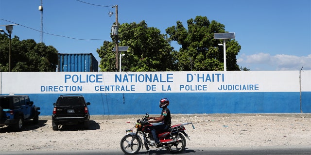 A man rides a bike in front of a main Haitian police station, where according to local media, a group of foreign nationals including Americans were detained, after anti-government protests, in Port-au-Prince, Haiti. (Ivan Alvarado / REUTERS)