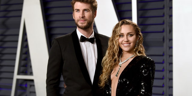 Liam Hemsworth, left, and Miley Cyrus arrive at the Vanity Fair Oscar Party.