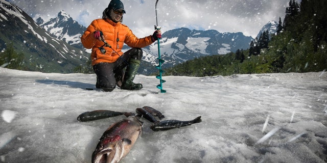 A fisherman is seen fishing on ice. A large chunk of ice broke free Monday in Minnesota's Upper Red Lake, stranding more than 100 people, authorities said.