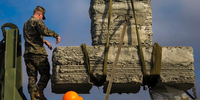 Marines with 7th Engineer Support Battalion, 1st Marine Logistics Group, work to secure a concrete bridge support column during the concrete printing exercise at Camp Pendleton, Calif., Dec. 12, 2018.