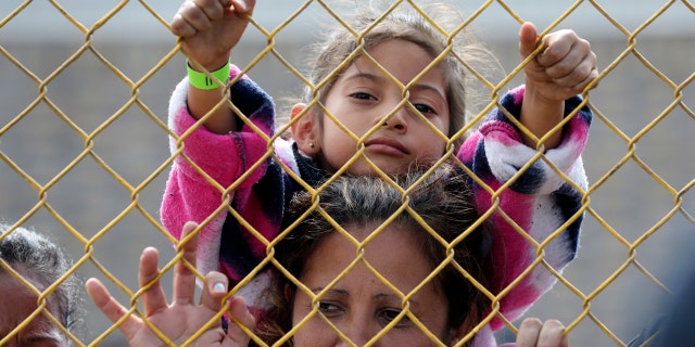 Six-year-old Daniela Fernanda Portillo Burgos sits on the shoulders of her mother, Iris Jamilet, 39, as they look out through the fence of a immigrant shelter in Piedras Negras, Mexico, Tuesday, Feb. 5, 2019.