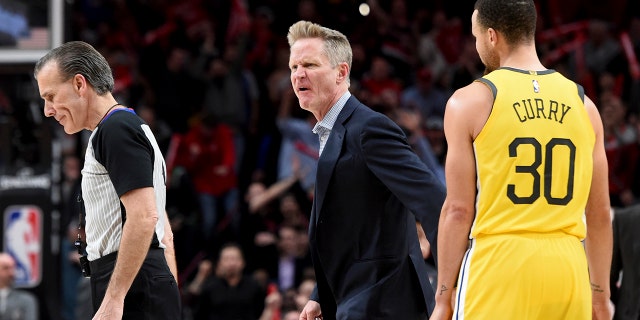 Golden State Warriors coach Steve Kerr, center, yells at referee Ken Mauer, left, after being called for a technical foul, while guard Stephen Curry, right, watches during the second half of an NBA basketball game against the Portland Trail Blazers in Portland, Ore., Wednesday, Feb. 13, 2019. The Blazers won 129-107.