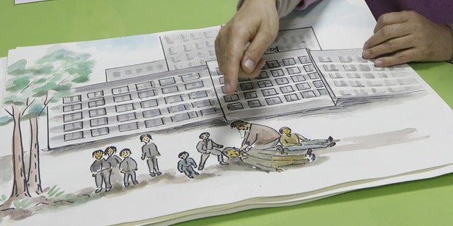 In this Dec. 21, 2018, photo, North Korean defector Kwak Jeong-ae, 65, shows a drawing about North Korea during an interview in Uijeongbu, South Korea. Experts and defectors say most of North Korea’s underground Christians do not engage in the extremely dangerous work of proselytizing. Instead, they largely keep their beliefs to themselves or within their immediate families.