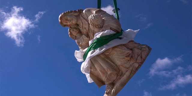 February 7, 2019 - Palm Beach, Florida, U.S. - A crane hoists a heavy limestone sculpture of Jesus with two children high above the roof of St. Edward Roman Catholic Church, to its base in the church hall courtyard. (Damon Higgins/Palm Beach Daily News via ZUMA Wire)
