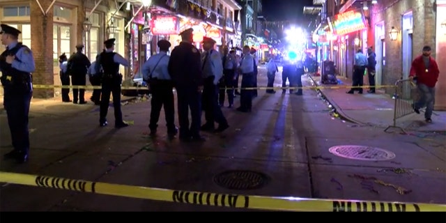 A woman was killed and a security guard was injured after a man stole the guard's gun and opened fire on Bourbon Street in New Orleans early Sunday, officials said.