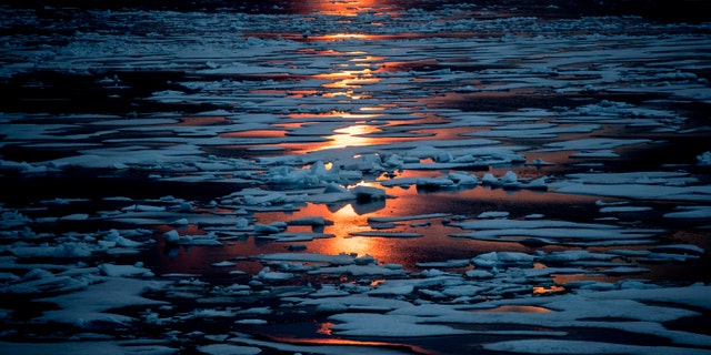 FILE- In this July 23, 2017, file photo the midnight sun shines across sea ice along the Northwest Passage in the Canadian Arctic Archipelago.