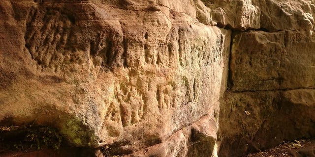 Roman graffiti carved into the soft sandstone of the quarry in Gelt Forest. (Historic England)