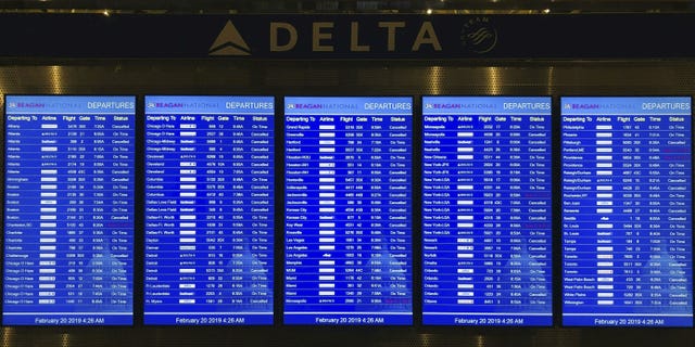 The flight status of dozens of scheduled flights departing from Washington Ronald Reagan National Airport in Washington is visible on February 20, 2019.