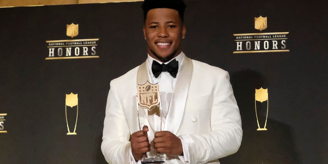 Saquon Barkley, of the New York Giants, poses with the award for AP offensive rookie of the year. (Photo by AJ Mast/Invision for NFL/AP Images)
