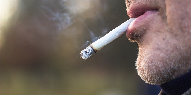 A man smokes a cigarette outdoors