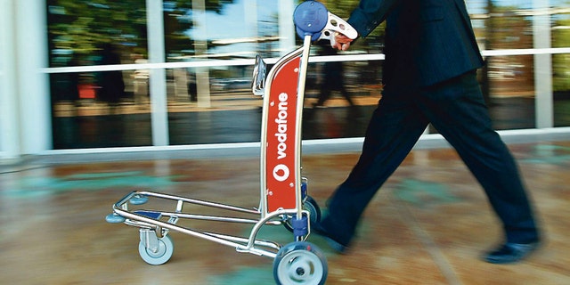 The woman was seen trying to push the luggage cart while it was upturned on its side.