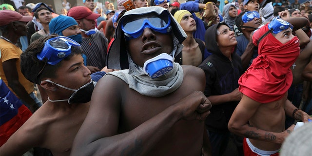 Venezuelan migrants under the Simon Bolivar International Bridge plead for people to support them with food and water so they can continue protesting in La Parada near Cucuta, Colombia, Sunday, on the border with Venezuela. (AP Photo/Fernando Vergara)