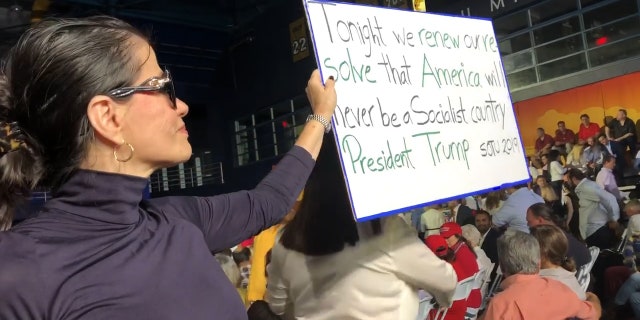 Venezuelan holds up sign at Trump's speech in Miami: "Tonight we renew our resolve that America will never be a socialist country."