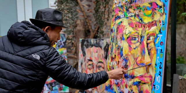 Artist Tran Lam Binh puts the final touches to a portrait of U.S. President Donald Trump in Hanoi, Vietnam, Feb. 25, 2019. (Associated Press)