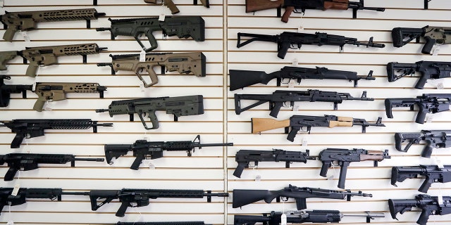 Semi-automatic rifles fill a wall at a gun shop in Lynnwood, Wash. (AP Photo/Elaine Thompson, File)